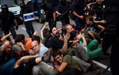 La policía intenta disolver una sentada de manifestantes que impide el paso de uno de los camiones de basura.