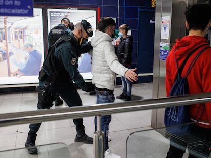 Un agente de la Guardia Civil cachea a un joven en un control para prevenir la violencia entre bandas juveniles, en la estación de metro de Arganda del Rey (Madrid).