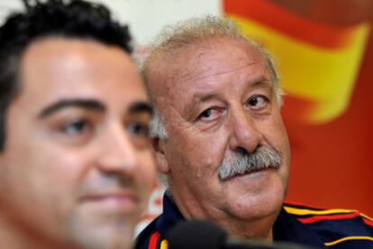 Xavi responde a la prensa ante la mirada de Del Bosque.