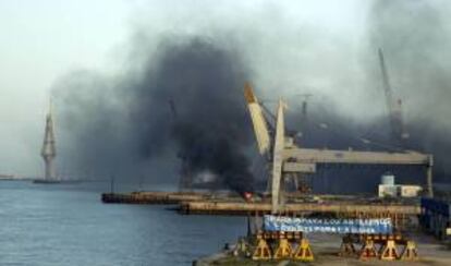 Vista de los Astilleros de Cádiz, donde los extrabajadores de los centros de Navantia en Puerto Real y San Fernando han prendido fuego a unos neumáticos en el interior de las instalaciones, una acción que coincide con la celebración entre hoy y mañana de la XXII Cumbre Iberoamericana de Jefes de Estado y de Gobierno en la ciudad gaditana.