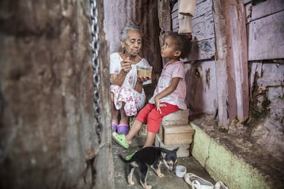 Una abuela da de comer a una de sus nietas en la Cota 905, una de las más azotadas en la ciudad por la violencia, el paro y el índice de malnutrición. Organizaciones como Alimenta La Solidaridad han abierto un comedor infantil donde implican a las madres y a los vecinos para identificar a los niños más afectados por la falta de alimentación.