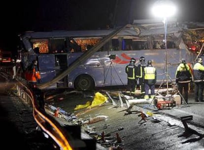 Varios integrantes de los servicios de Emergencia, junto al autobús siniestrado en la autopista A-7.