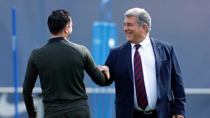 El presidente del FC Barcelona, Joan Laporta (a la derecha) saluda al entrenador del equipo, Xavi Hernández, este lunes.