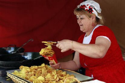 Una mujer llena un cucurucho de papas.