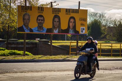 Un motociclista circula frente a propaganda electoral, en Santa Fé, Argentina.