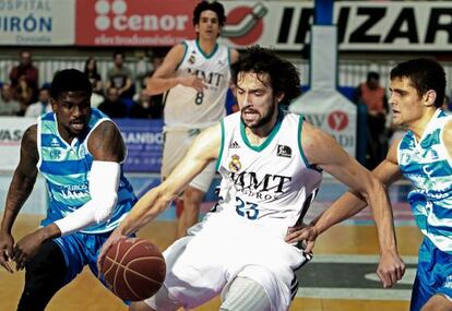 Los jugadores del Lagun Aro Jermaine Taylor (izquierda) y Raulzinho Neto intenta frenar al base del Real Madrid Sergio Llul.