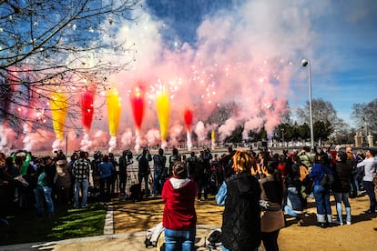 Varias personas observaban el humo de colores durante la primera 'mascletà' madrileña, celebrada este domingo en el puente del Rey de Madrid Río.
