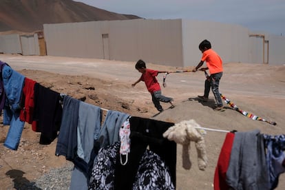 Dos niños juegan en un terreno ocupado en el barrio La Mula de Alto Hospicio, Chile, en 2021.