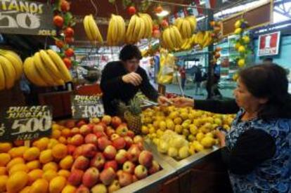 Fotografía fechada el 7 de octubre de 2013 que muestra a una mujer mientras compra frutas en un puesto del mercado de la Vega Central, en Santiago de Chile (Chile).