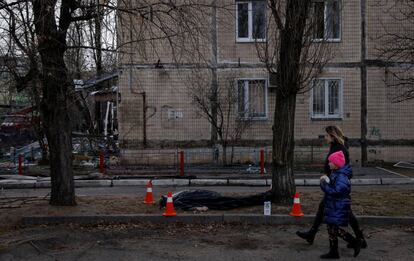 Una mujer y un niño pasan junto a un cuerpo de una persona en el barrio de Obolon, en Kiev. El presidente ucranio, Volodímir Zelenski, señaló anoche que sus representantes estaban negociando un posible encuentro con el mandatario ruso, Vladímir Putin. “Nuestra misión es clara: hacer todo lo que sea posible para asegurar una reunión entre los dos presidentes”, dijo en un vídeo. Y destacó una de las exigencias de Ucrania, la apertura de corredores humanitarios para las ciudades sitiadas. Según afirmó, más de 130.000 personas habían sido evacuadas en los últimos seis días, pero lamentó que todavía quedaba mucha gente atrapada en enclaves como Mariupol.