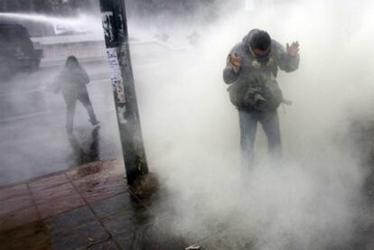 Un fotógrafo se proteje de los gases lacrimógenos lanzados por la policía ayer en Valparaíso.