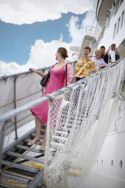 Pasajeros descendiendo por la pasarela de un crucero.