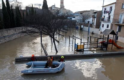 Personal de Protección Civil desalojan a una mujer durante las fuertes inundaciones en Tudela por la crecida del río Ebro.