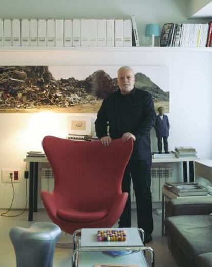 Pérez de Albéniz se apoya sobre la Egg Chair de Fritz Hansen. En primer plano, salvamanteles de la tienda del MoMA. En la pared, obra de Basurama.