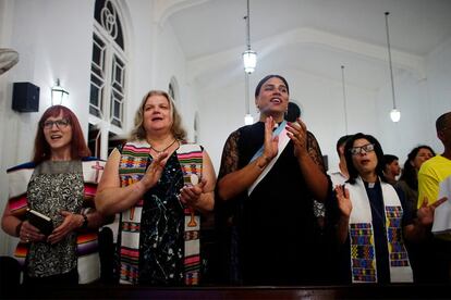 La reverendo baptista Allyson Robinson (izq), la pastor Cindy Bourgeois, Alexya Salvador y la pastor Elaine Saralegui, cantan durante una misa en Matanzas, Cuba. Las religiosas vestían estolas con los tonos trans, azul claro, rosa y blanco.