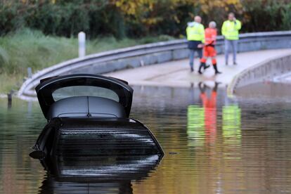 Un coche parcialmente sumergido en el agua en una carretera inundada de Mandelieu-la-Napoule, en el sur de Francia, tras las lluvias torrenciales.