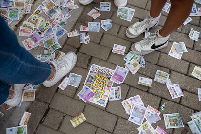 Papeletas de la tómbola Antojitos llenan el suelo de la feria de Valladolid.