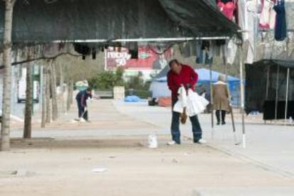 Comerciantes del mercadillo del Zaidn recogen la basura acumulada en sus puestos.