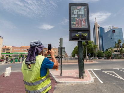 Un hombre fotografía un termómetro que marca 47 grados este miércoles en la Ronda de Levante de Murcia.