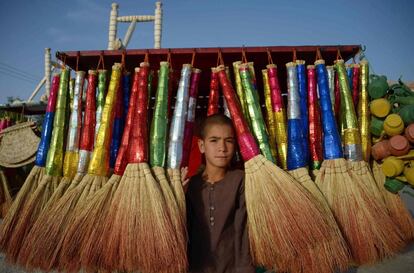 Un ni?o vende escobas en un puesto cerca de la carretera en Mazar-e Sarif (Afganistn).