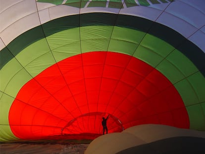 Un empleado de Green Aerostación supervisa el inflado del globo antes de un viaje.