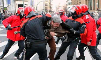 Agentes de la Ertzaintza forcejean con un manifestante ante un centro comercial de Bilbao durante la jornada de huelga general convocada por los sindicatos nacionalistas.