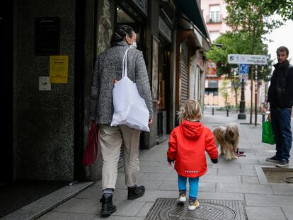 Una mujer camina junto a su hijo este martes por una calle de Madrid, este martes.