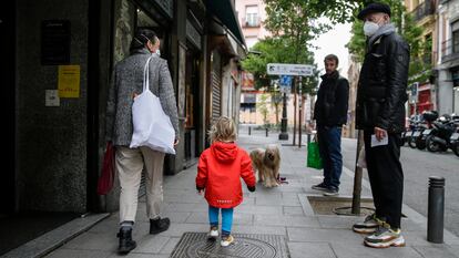 Una mujer camina junto a su hijo este martes por una calle de Madrid, este martes.