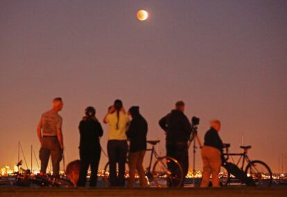 Observadores contemplam a 'Lua sangrenta' em Melbourne durante o eclipse.