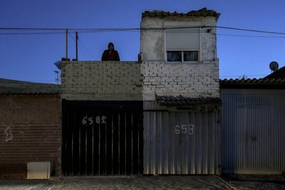 Un vecino se asoma a la azotea de su casa durante al atardecer, cuando la banda sonora de la Cañada Real empieza a ser el ruido de los generadores.