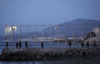 Varios polic&iacute;as vigilan durante la madrugada del mi&eacute;rcoles el espig&oacute;n fronterizo del Tarajal, que la Delegaci&oacute;n del Gobierno quiere alargar con un pantal&aacute;n flotante. 