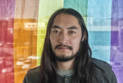 Jack Ganbaatar posa frente a una bandera LGBTI.