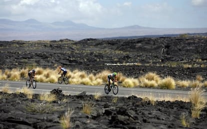 Triatletas entre campos de lava en Kailua-Kona, Hawái, durante la prueba de bici del 'Ironman'.
