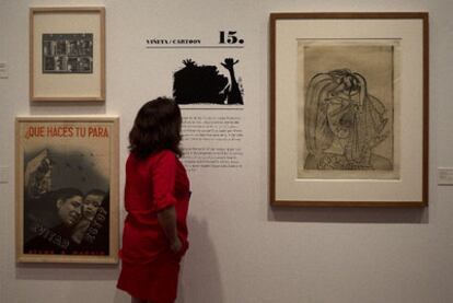 Una mujer observa algunas obras de la exposición de <i>Viñetas en el frente</i> en el Museo Picasso de Málaga.