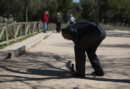 Un jubilado coloca el cilindro de metal con el que se juega al chito, en el Parque Pradolongo (Usera, Madrid).