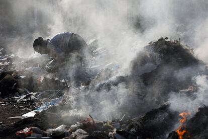 Un hombre busca material reciclable de un montón de desechos informáticos, en Karachi, Pakistán.