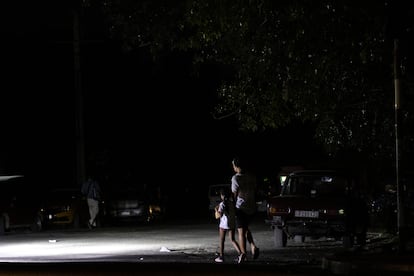 Dos personas caminan en medio de un apagón en La Habana, en febrero.