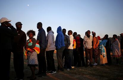 Votantes zimbabuenses hacen cola para emitir su voto en un colegio electoral en Harare.