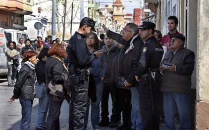 Vecinos y manifestantes de la plataforma Salvem El Cabanyal piden ver la licencia de derribo de un inmueble ante la Policía Nacional.