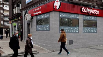 Viandantes caminan frente a un restaurante Telepizza en Madrid.