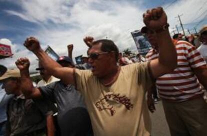 Un grupo de personas protesta con pancartas frente a un grupo de policías a las afueras de la sede del Instituto Nicaragüense de Seguridad Social (INSS) en Managua (Nicaragua).