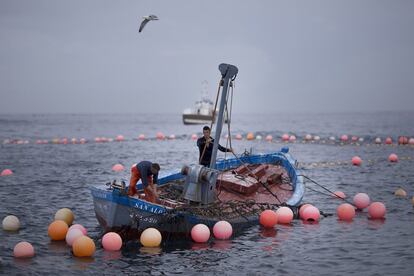 Dos pescadores preparan la red.