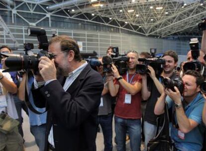 El presidente del PP, Mariano Rajoy, fotografía a los numerosos periodistas que han acudido a la reunión de Valencia.