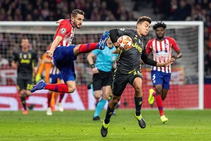 El delantero de la Juventus Paulo Dybala intenta escaparse de Koke Resurrección, del Atlético de Madrid, durante el encentro de ida de octavos de final.
