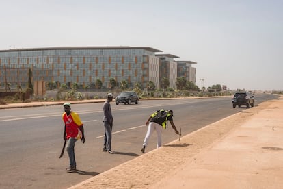 Tres trabajadores retocan las aceras del barrio de Diamniadio, el pasado mes de mayo. En solo cinco años, una nueva ciudad ha ido emergiendo en medio de la nada a 30 kilómetros de Dakar. 