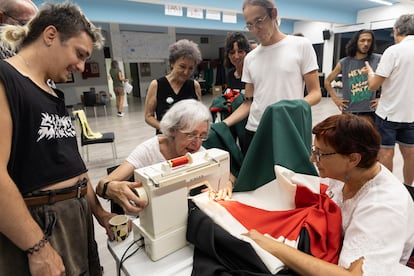 Carmen y Pilar terminan de coser la bandera palestina rodeadas de compañeros, el 8 de septiembre de 2025.