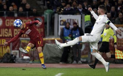 El delantero de la Roma, Cengiz Under, centra el balón ante la presión del defensa del Real Madrid, Sergio Ramos.