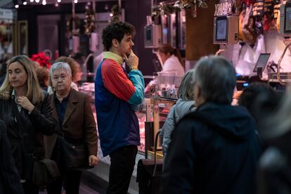 Un jove compra a una parada del Mercat de Sant Antoni de Barcelona.