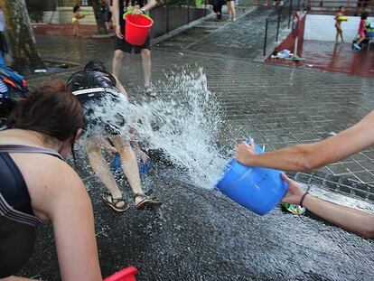 Participantes en la Batalla Naval de Vallecas se arrojan cubos de agua en la calle.