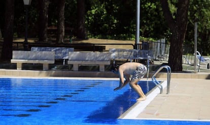 Un hombre se dispone a tirarse al agua de la piscina de Aluche.